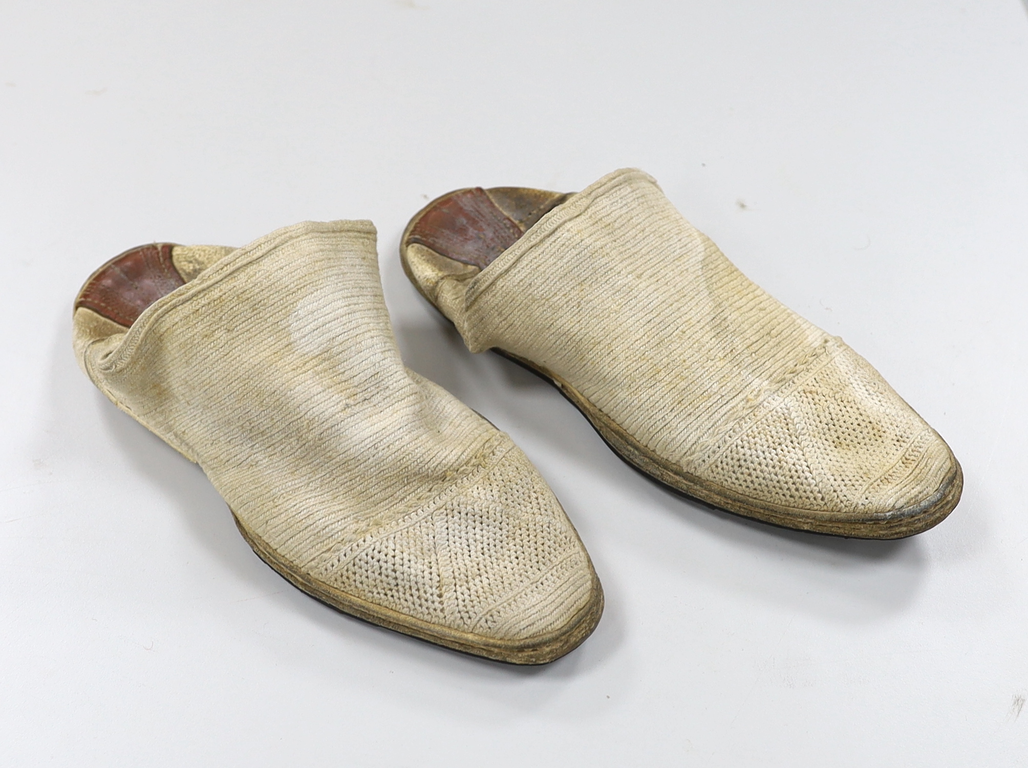 A pair of 1970's Iranian ‘Geevay’ slippers, the soles made from tyres and tops hand crochet together with a 19th century fine red wool hood with gold embroidery and a red tassel, possibly Spanish, ecclesiastical hood